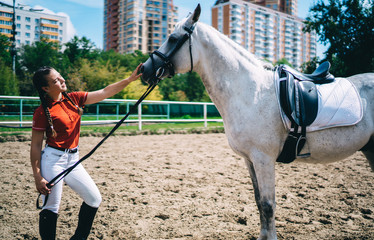 Female jockey training gray horse