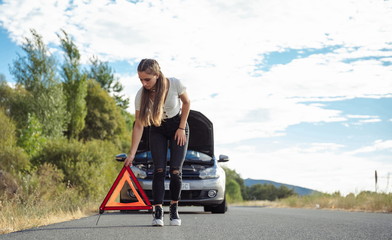 Girl placing fault signaling car triangle