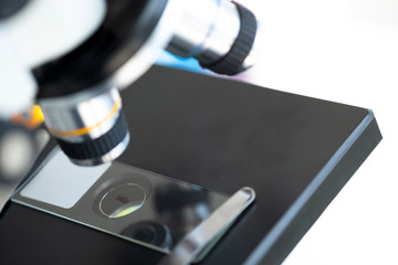 Closed up of microscope in the laboratory with white background and blurred background. Coronavirus and research concept