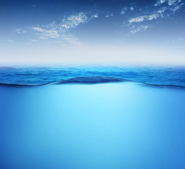 Sea landscape with underwater space deep under water ocean scene wavy water surface .against blue sky with little clouds