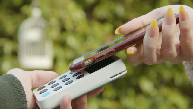 Contactless Payment With A Smart Phone Outside An Independent Cafe Female Hand