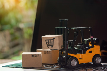 Forklift loader a pallet with Paper cartons or parcel on laptop, Logistics and delivery service for shopping online