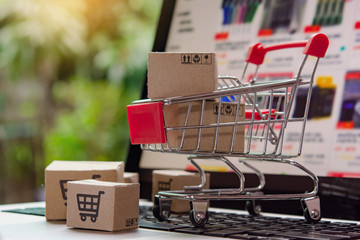 Shopping online. cardboard box with a shopping cart logo in a trolley on laptop keyboard. Shopping...