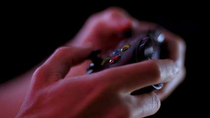 Playing video games close up with a black background