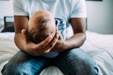 center portrait of dad holding newborn baby