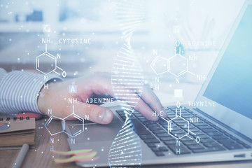 DNA hologram with businessman working on computer on background. Concept of bioengineering. Double exposure.