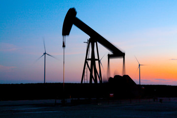 Pump jack in motion on a wind farm in Ft. Davis, Texas