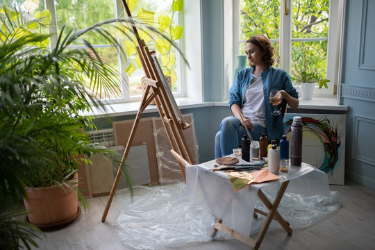 Relaxed lady with wine admiring painting