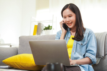 Asian woman freelance or online shop owner seller receive order from customer by mobile phone and working on computer as work from home in new lifestyle business