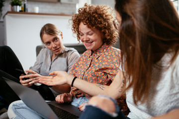 Happy businesswomen talking and laughing in office. Beautiful women on coffee break..