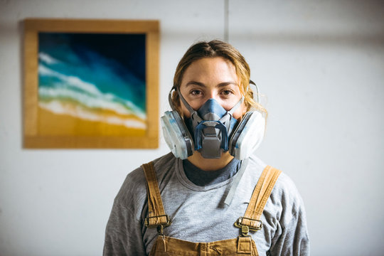 Portrait of female resin artist in homemade art studio with respirator