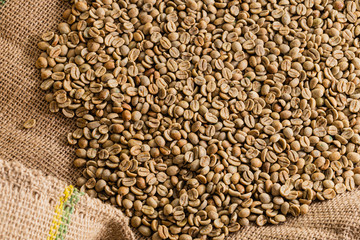 cafe en grano verde sobre tela de bolsa de arpillera
