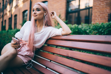 Contemplative hipster girl using 4g internet connection for listening online audio book pondering on interesting plot, thoughtful Caucasian woman in headphones enjoying free time for radio music