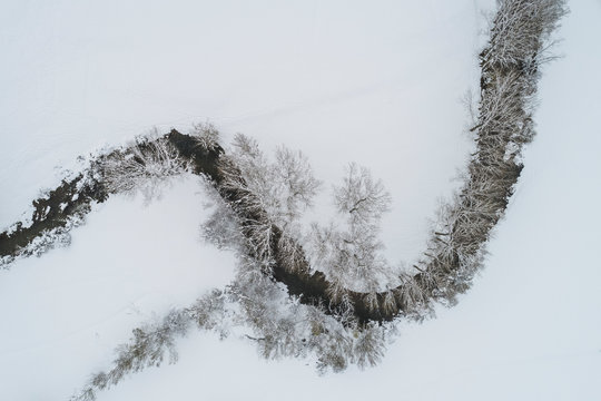 snowy curve of river from aerial view