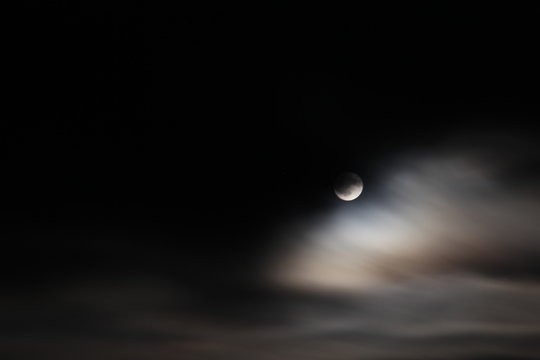 Full Moon Among a Dark Sky and Whispy Clouds