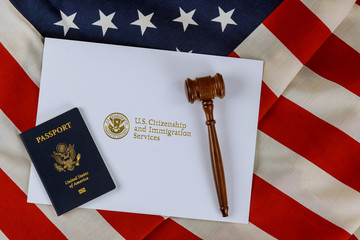judge's gavel, lawyers office deportation U.S. Citizenship and Immigration Services of naturalization with USA passport over U.S. flag © Cavan
