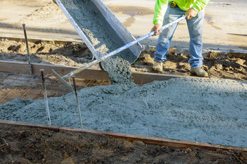 Laying down a new sidewalk in wet concrete on freshly poured sidewalks