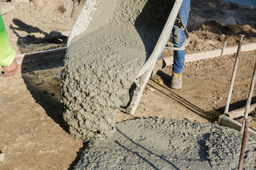 Construction process making of freshly poured cement wheelbarrow with shovel full of cement...
