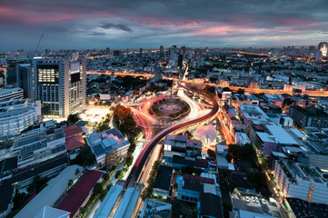 Cityscape of Victory Monument with car traffic on roundabout road at Bangkok, Thailand