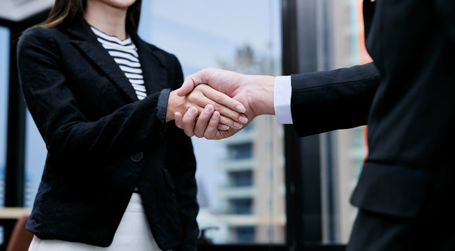 Young Asian business woman is shaking hand with a businessman.