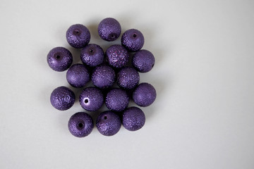 purple round crushed beads on a gray background . needlework . craft