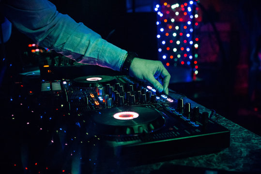 DJ plays electronic music in a nightclub at a party