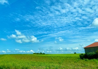 Blick über das Donaumoos mit Feldern und Wolkenbildern