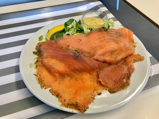 Smoked Salmon Gravlax Salad with Mustard Sauce in Plate Served with Tray at Restaurant. Healthy Fast Food.
