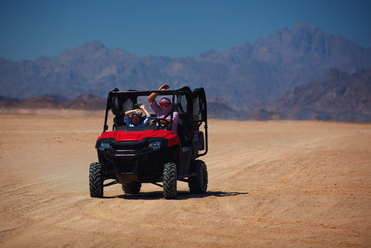 Excited Family Having A Safari Tour Through The Desert In Buggy Car. Thrill Adventures