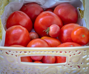 red tomatoes lies in a white bowl