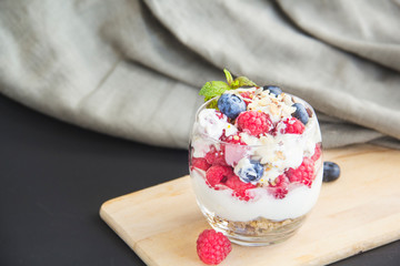 Healthy blueberry, raspberry and walnut parfait in a glass on a white background