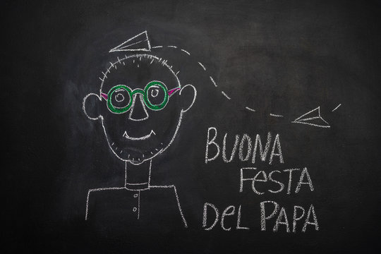 Inscription in Italian Happy Father's Day! children's picture of happy daddy made with chalk on blackboard
