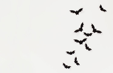 Halloween and decoration concept - black paper bats flying over white background