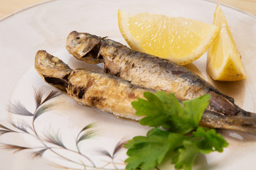 grilled sardines with lemon and parsley on the plate