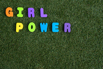 Girl power spelt out on green grass background with colourful letters