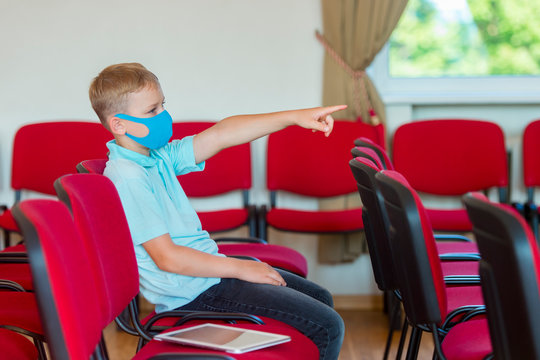 School kid with blue mask against virus at lesson. Safe back to school during pandemic concept. Social distancing to fight COVID-19