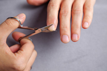 A man cuts his nails on his hands