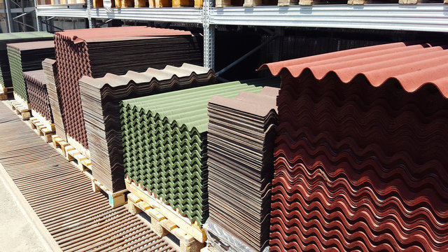 A stack of green and red ondulin sheets. Modern roofing material