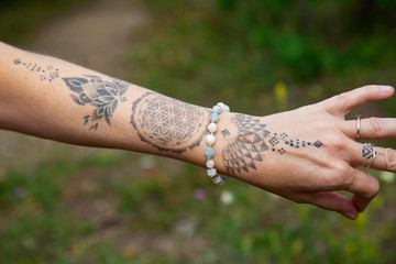 Outdoor closeup of tattoo hand with morganite bracelet