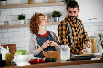 Boyfriend and girlfriend making delicious food at home. Loving couple cooking in kitchen..