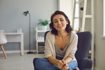 Obraz premium Young smiling woman looking at camera during online conference call