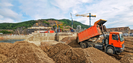 Construction of a hydroelectric power station, strengthening of the coastal strip with mountain soil using cargo dump trucks © Letopisec