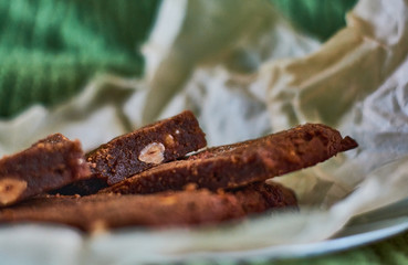 Homemade delicious, fresh pastries. Chocolate dessert with nuts, brownies on parchment.