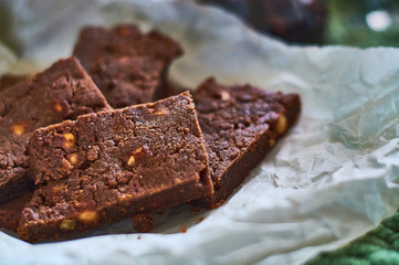 Homemade delicious, fresh pastries. Chocolate dessert with nuts, brownies on parchment.