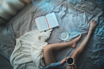 Obraz na płótnie Canvas pretty brunette woman in morning bed with books and coffee