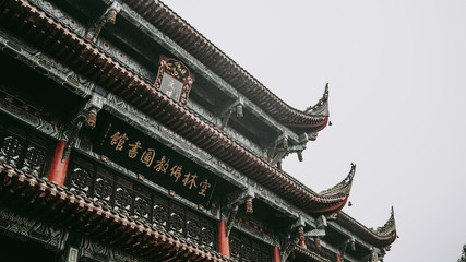 Fototapeta na wymiar traditional Chinese rooftop at the national museum in Chengdu, oriental woodcarving details, soft focus