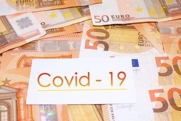 Close up of banknotes of 50 euros with a "Covid-19" sign in the middle, concept of business during Corona Virus