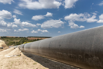 Gas and oil pipeline construction. Pipes welded together. Big pipeline is under construction. Cloudy sky