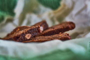 Homemade delicious, fresh pastries. Chocolate dessert with nuts, brownies on parchment.