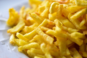 Freshly fried delicious French fries on a white plate